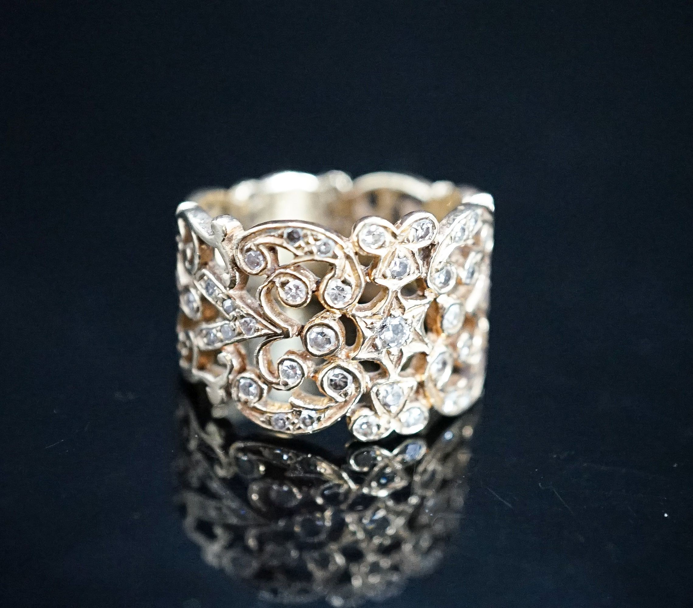 A continental pierced 14k and diamond chip set band, size L/M, gross weight 8.2 grams.